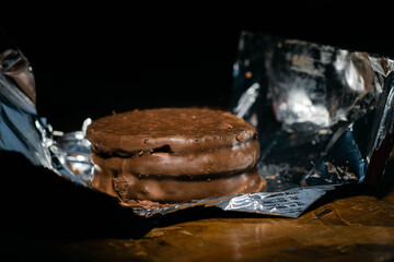 primer plano de alfajor triple capa de chocolate y crema de mani industrial con envoltorio metalizado tipico argentina cordoba