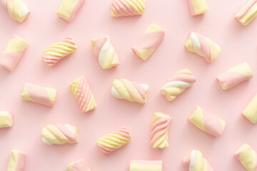 MANY DIFFERENT COLORED MARSHMALLOWS ON PINK BACKGROUND. SWEETS FOR CHILDREN'S CELEBRATIONS. TOP VIEW.