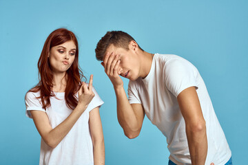 enamored man and woman in jeans and a T-shirt on a blue background hug each other and have fun