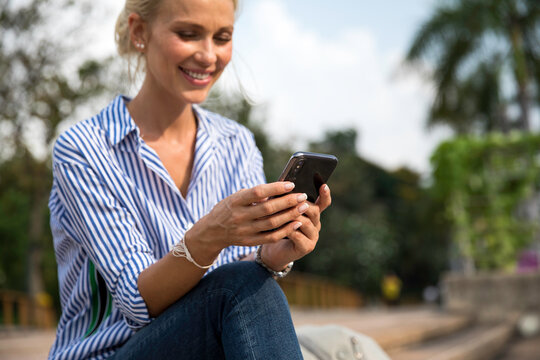 Attractive blonde woman using phone outdoors