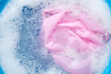Color clothes soak in powder detergent water dissolution. Laundry concept