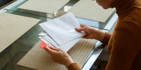 Letters and white envelopes in hands of a woman at the table