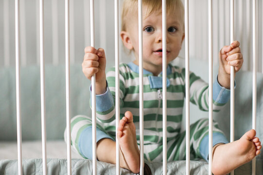 toddler sitting in his crib