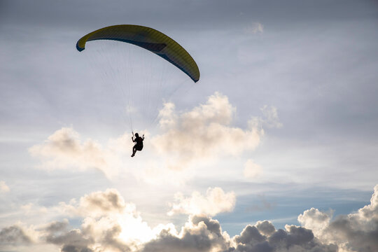 A paraglider flies high above a lake