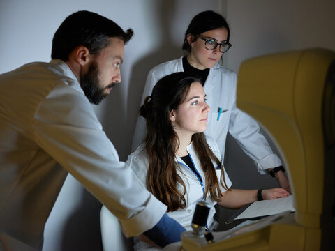 Professor with students working with technology equipment
