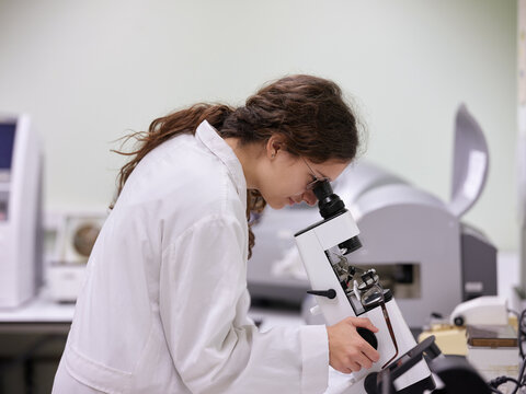 Young woman working with microscope