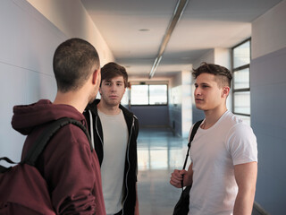 Young men students talking in hall