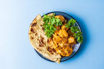 Indian snacks samosa garlic naan bread butter chicken on wooden table