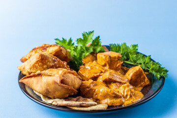 Indian snacks samosa garlic naan bread butter chicken on wooden table