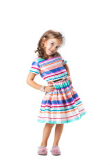 happy little girl wearing colorful dress posing in studio, isolated on white