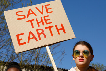 Young woman with ecological poster on street