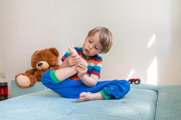 Three years old blond boy at home
