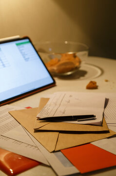 Documents and letters near tablet on kitchen table