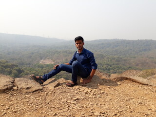 person sitting on the top of mountain, Mumbai Sanjay Gandhi National Park top view, men sitting on top.