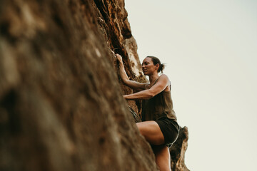 Woman climbing rock mountain
