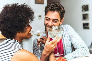 Close-up of happy couple looking at each other while drinking cocktails in bar