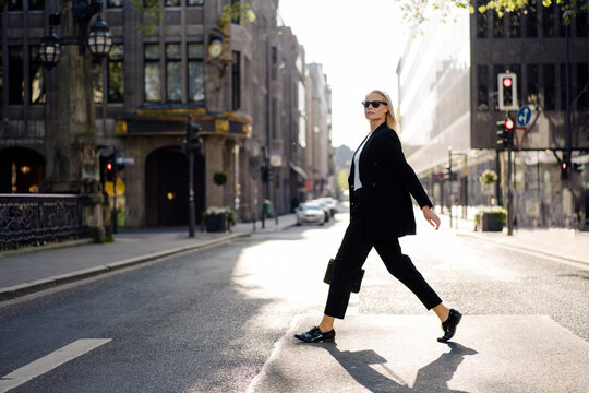 Fashionable female professional crossing street in city
