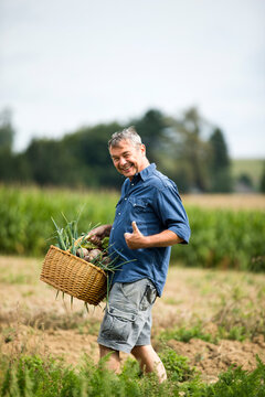 Man showing thumbs up while walking at farm