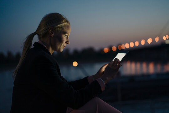 Confident businesswoman using digital tablet at dusk