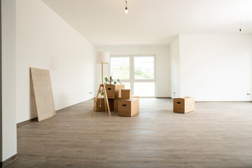 Electric lamp with cardboard boxes on hardwood floor in new house