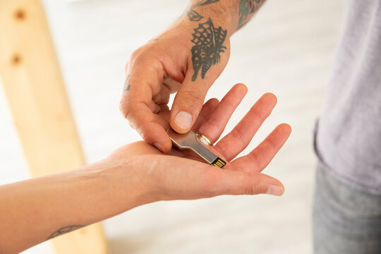 Close-up of man hand giving USB key to wife in new house