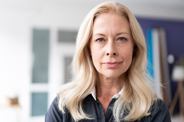 Close-up of confident female professional with blond hair in home office