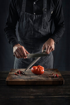 Man sharping knife while standing at table