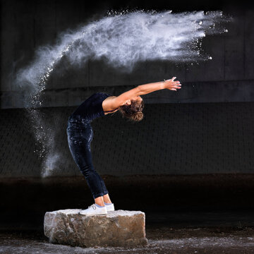 Woman dancing with flour against wall