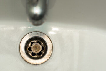 Turkish kurus coin is thrown away in dirty sink. Turkish lira and Turkish economy collapse concept. Copy space. Top view