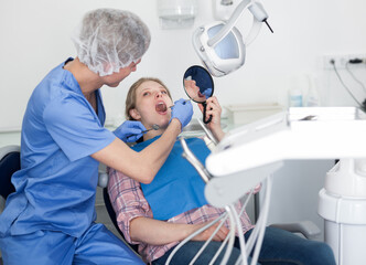 Obraz premium Dentist male in uniform is examinating of female in dental clinic. High quality photo