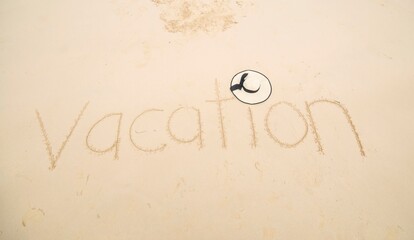 The word VACATION written at sand.