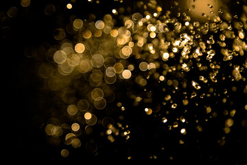 Gold bokeh of water fly and lights on black background
