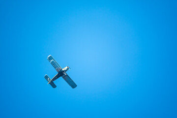 Retro green biplane plane in the blue sky © Dmitrii Potashkin