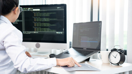 Asian Woman programmer typing source codes Programming On Computer in office, freelance web developer concept.