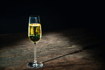 a glass of wine or champagne on a vintage wooden table background
