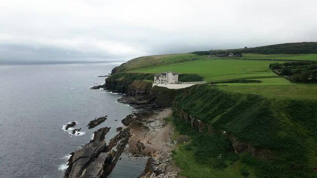 Beautiful Dunbeath Castle in Scotland overlooking the waves -aerial