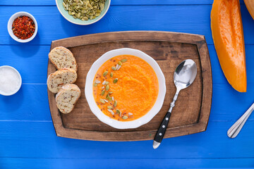 Tasty pumpkin cream soup in bowl on table