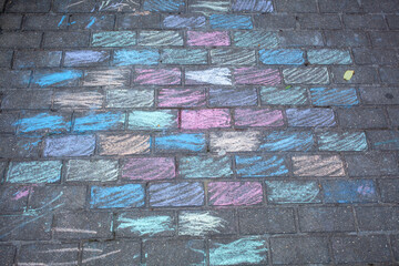 The paving stones on the playground are painted with crayons.