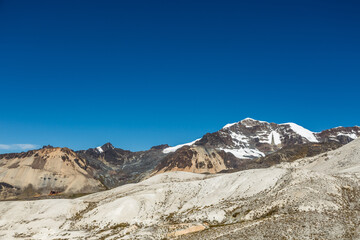 Nevados y monta&ntilde;as andinas con cielo azul 

