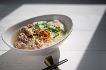 Thai style clear soup rice noodle in traditional bowl. Selective focus
