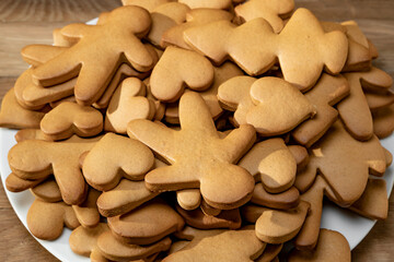 Gingerbread cookies of various shapes on a plate on a wooden table. Homemade handmade cookies. Close-up.