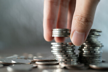 Hand put coins to stack of coins on white background, Investment and saving concept.