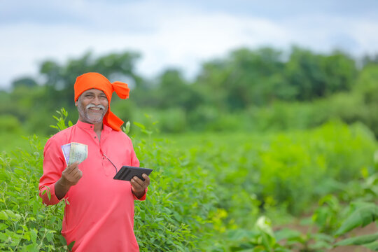 Indian Farmer With Money And Tablet