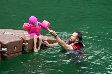 Asian family swimming at the Kenyir Lake, Malaysia.