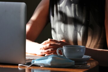 Woman working at home with face mask at the ready