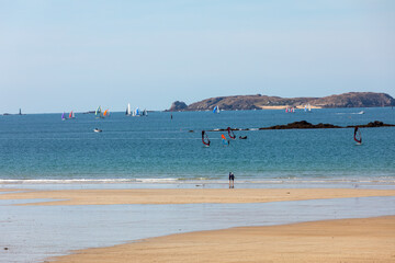  Windsurfers surfing along the beach in Saint Malo. Brittany, France