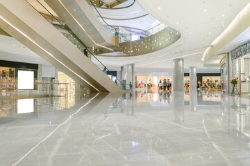 Hall of modern shopping mall with storefronts.