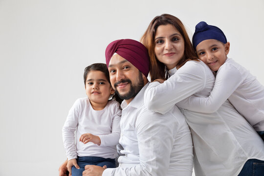 A HAPPY SIKH FAMILY POSING TOGETHER	