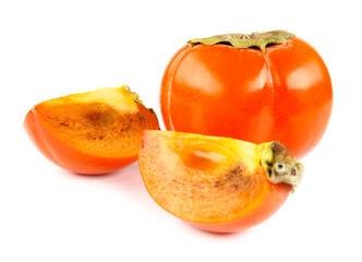 A whole and two slices of ripe persimmon are isolated on a white background.