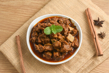 Traditional homemade Mutton curry from Asian cuisine.   Chukhandar gosht. Spicy delicious meat beef curry.  Bowl of tasty mutton roast Indian spices.  side dish of Ghee rice, Appam, Parotta, Puttu